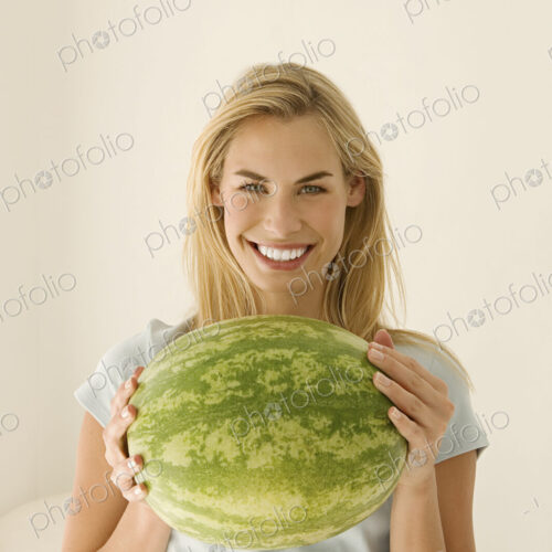 A woman holding a large green watermelon. A woman holding a large green watermelon.