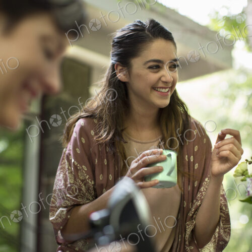 A woman holding a mug in her hand with a group of people. A woman holding a mug in her hand with a group of people.