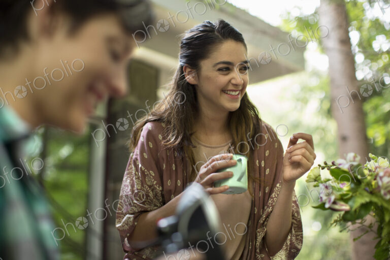 A woman holding a mug in her hand with a group of people.