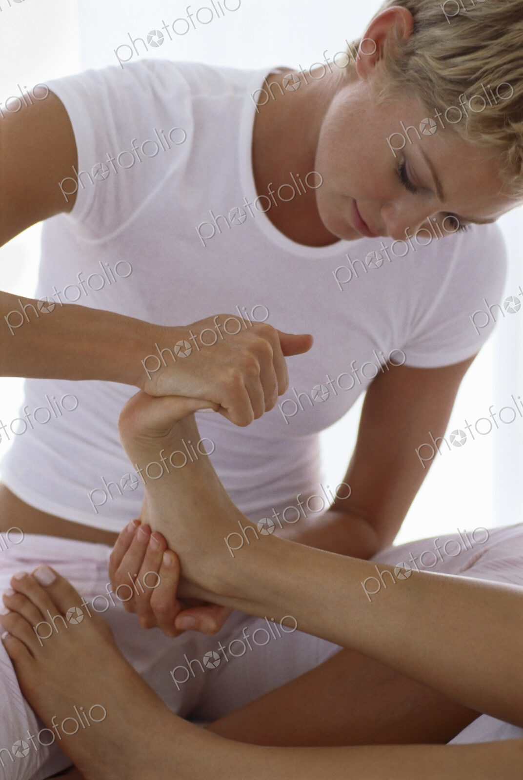 A woman holding a person’s foot and massaging and flexing the toes.