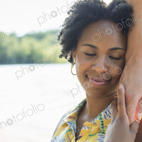 A woman holding a person's hand to her cheek and smiling. A woman holding a person's hand to her cheek and smiling.