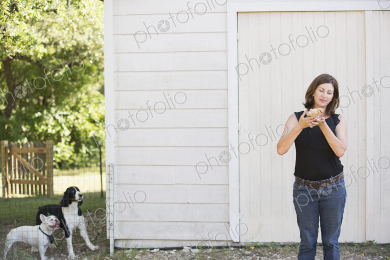 A woman holding a small fluffy chick, a baby bird in her two hands.