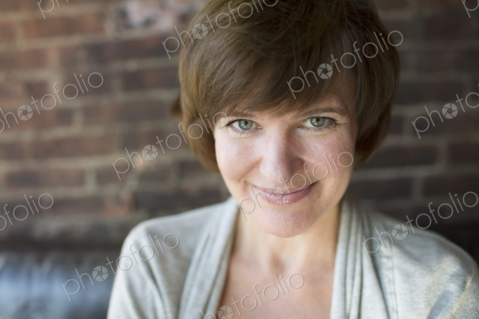 A woman in a coffee shop. Smiling. Head and shoulders.