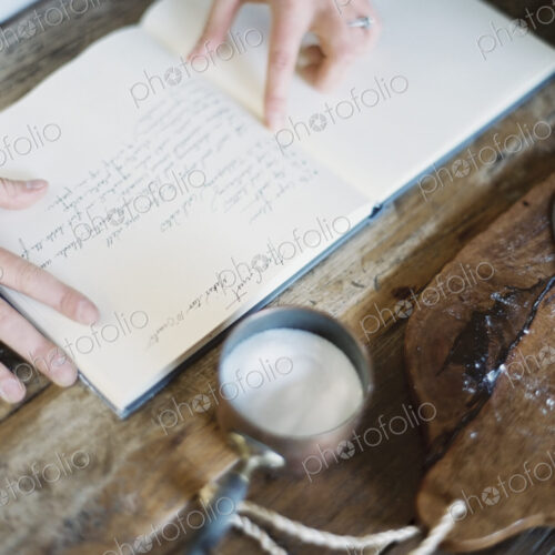 A woman in a domestic kitchen, reading a recipe book. A woman in a domestic kitchen, reading a recipe book.
