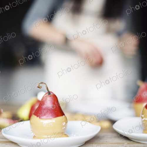 A woman in a domestic kitchen. Fresh organic pears dipped into a sauce for dessert… A woman in a domestic kitchen. Fresh organic pears dipped into a sauce for dessert…