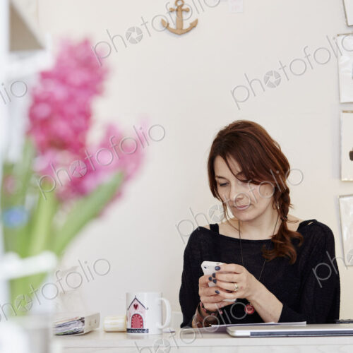 A woman in a gift shop making a call on a smart phone.