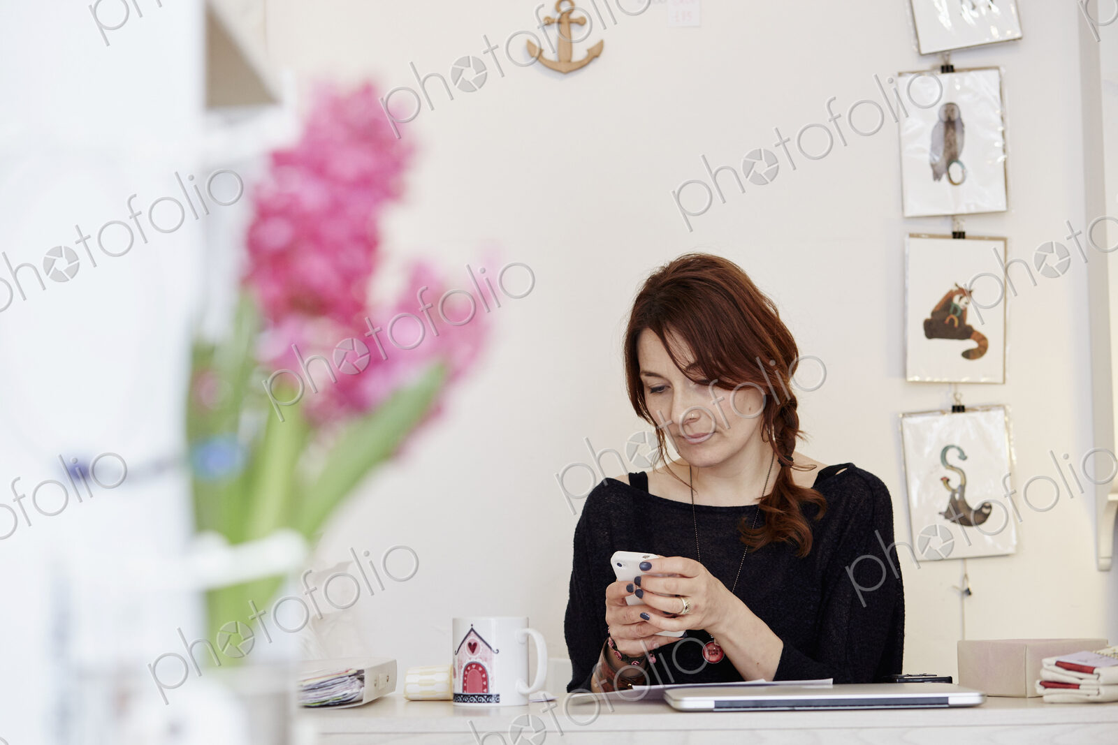 A woman in a gift shop making a call on a smart phone.