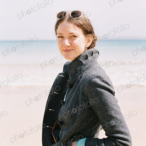 A woman in a grey coat on the beach. A woman in a grey coat on the beach.