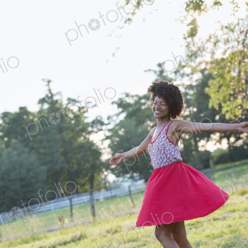 A woman in a red skirt, whirling around in the open air, with her arms outstretched. A woman in a red skirt, whirling around in the open air, with her arms outstretched.