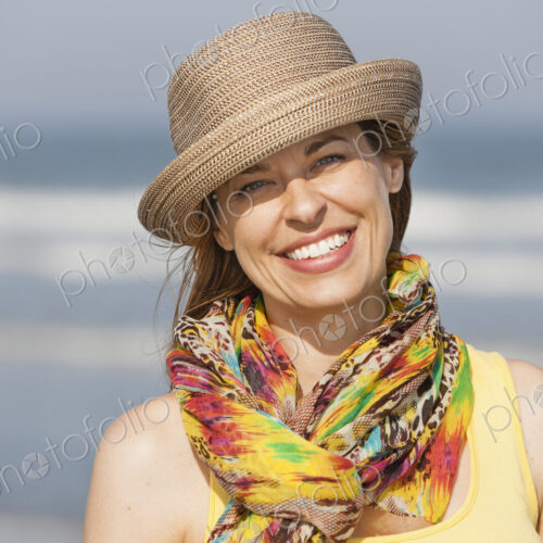 A woman in a sunhat and scarf on the beach on the New Jersey Shore, at Ocean City.
