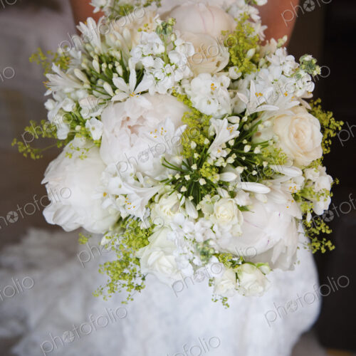 A woman in a white dress, a bride holding a bridal bouquet of white flowers, large… A woman in a white dress, a bride holding a bridal bouquet of white flowers, large…