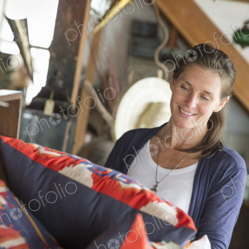 A woman in an antique store in a small town, with objects and furniture from the past.