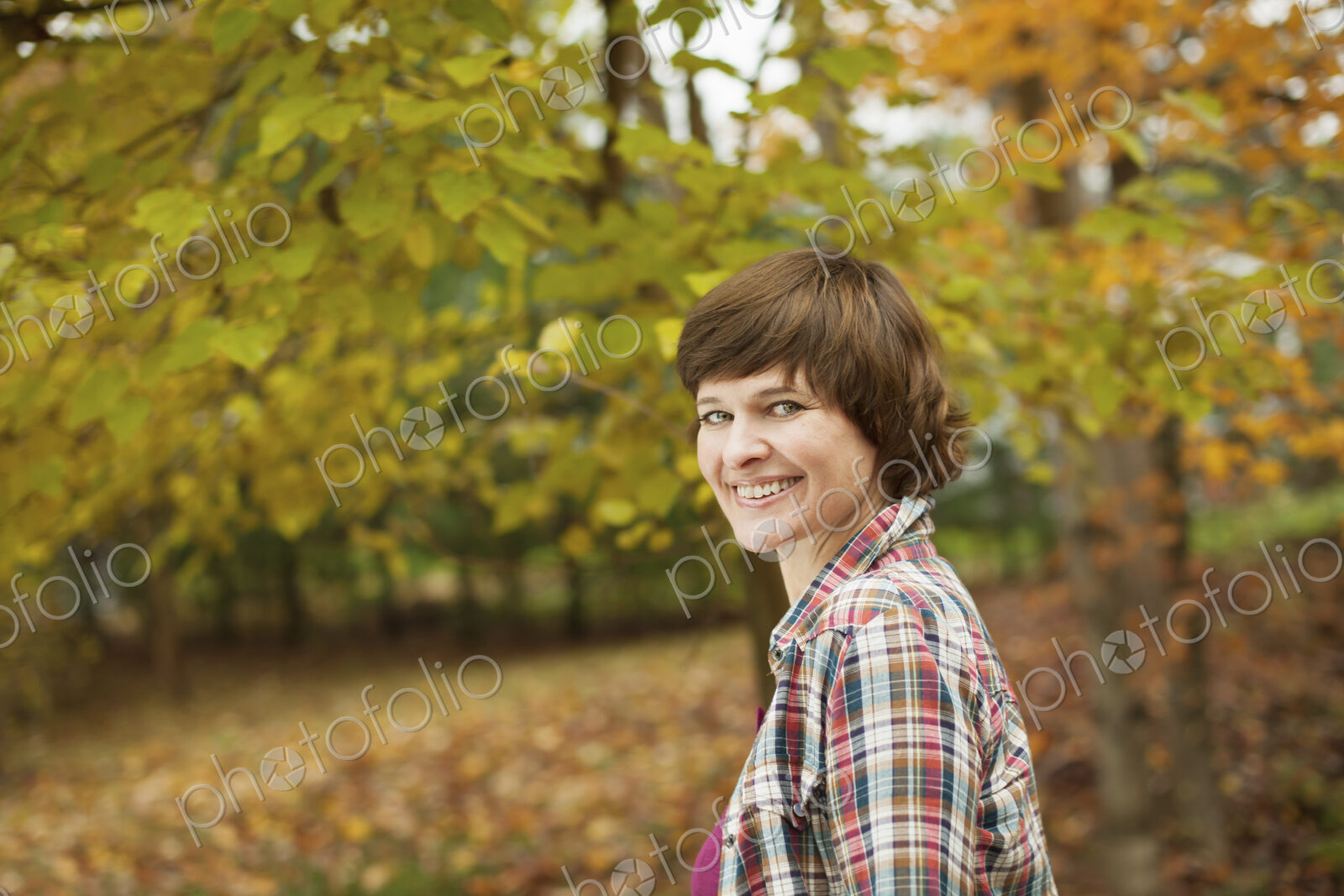 A woman in woodland on an autumn day.