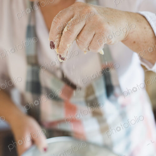 A woman measuring and sifting white flour, making a crumble topping. Home baking. A woman measuring and sifting white flour, making a crumble topping. Home baking.