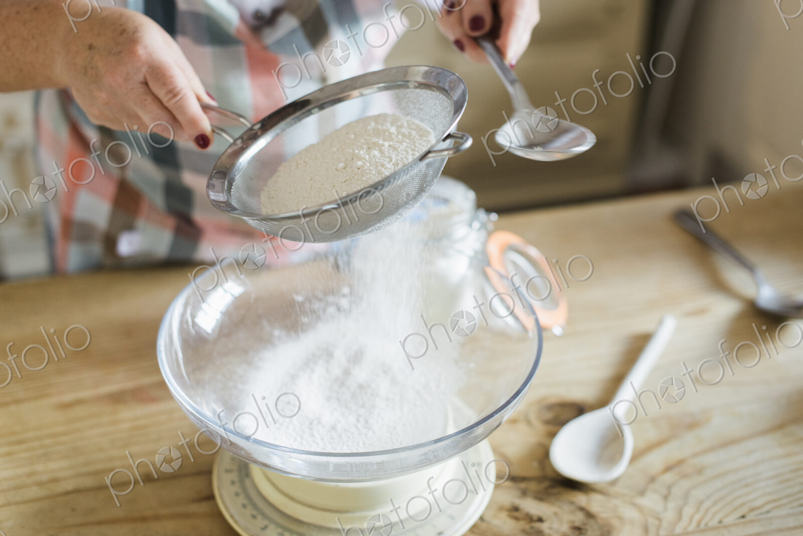 A woman measuring and sifting white flour. Home baking.
