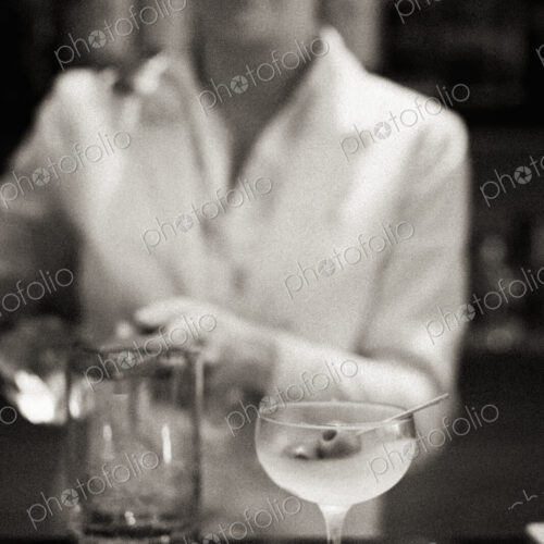 A woman mixing a cocktail, a mixologist at work.