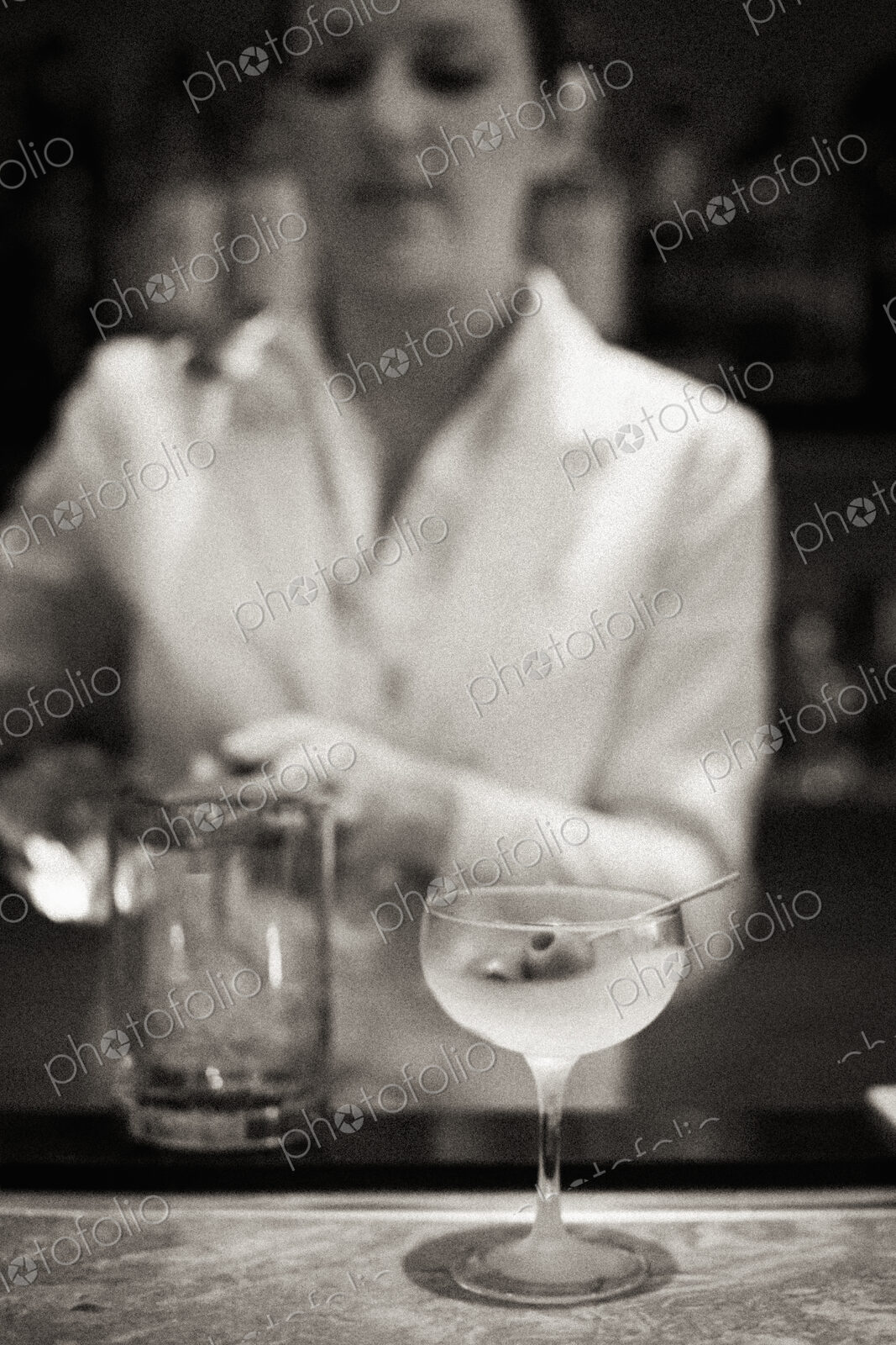 A woman mixing a cocktail, a mixologist at work.