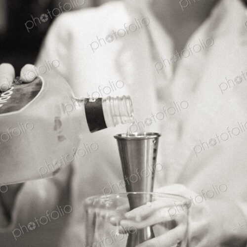 A woman mixing a cocktail, a mixologist at work.