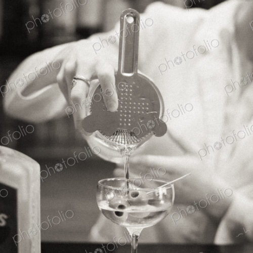 A woman mixing a cocktail, a mixologist at work.