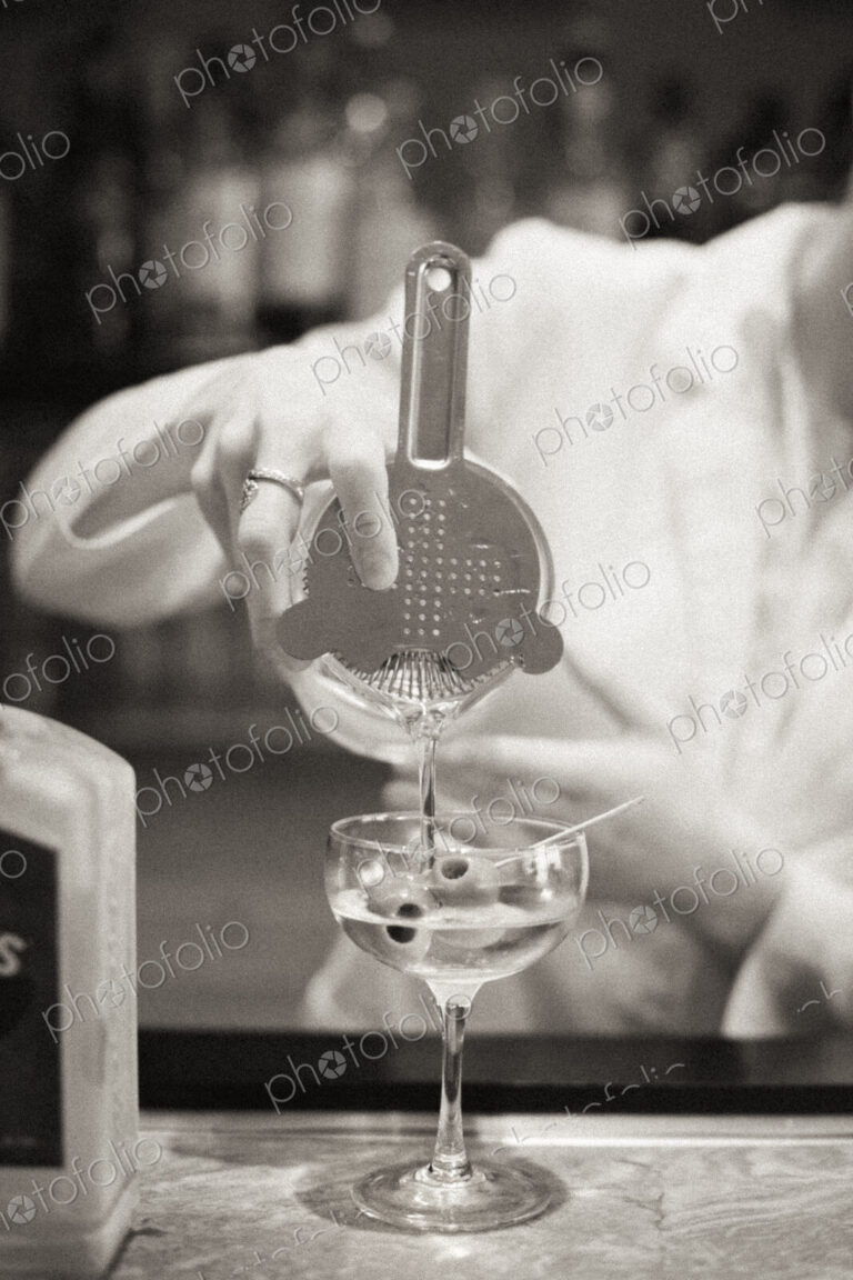 A woman mixing a cocktail, a mixologist at work.