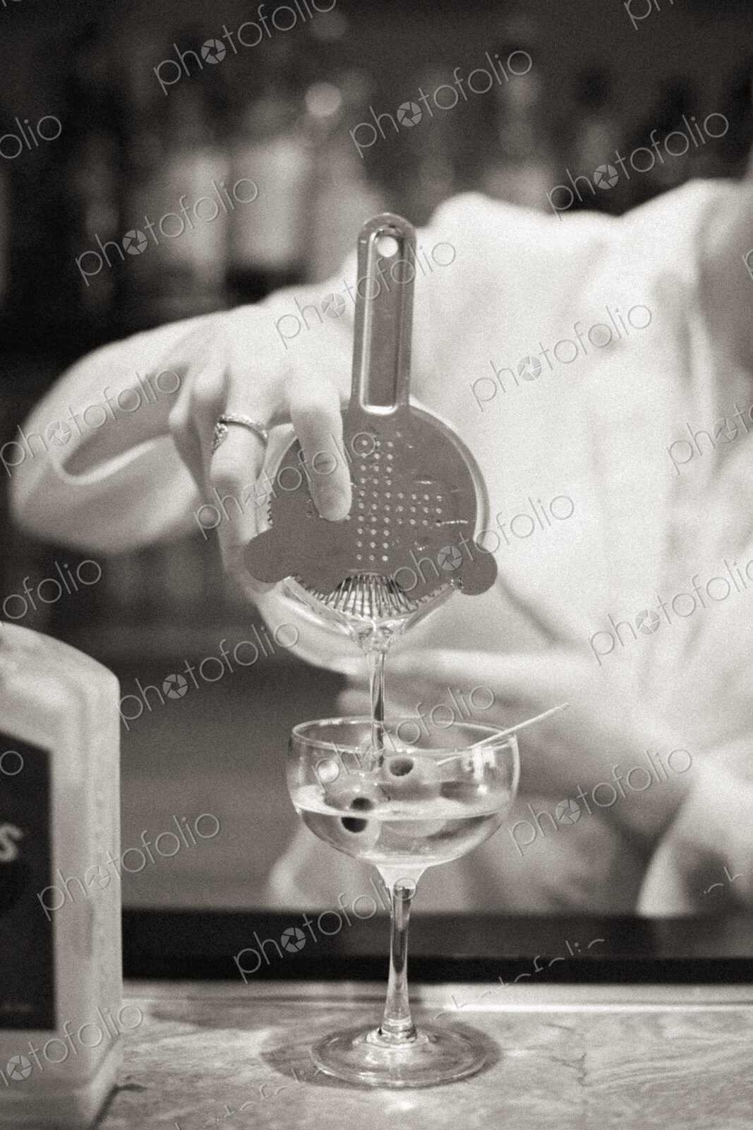 A woman mixing a cocktail, a mixologist at work.