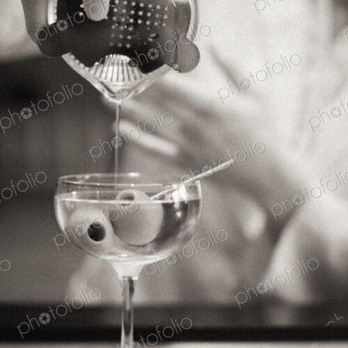 A woman mixing a cocktail, a mixologist at work.