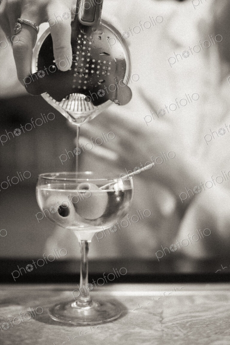 A woman mixing a cocktail, a mixologist at work.