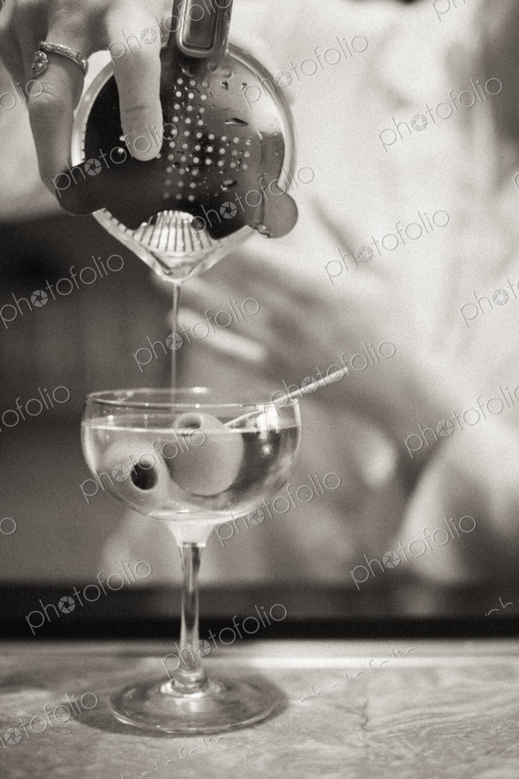 A woman mixing a cocktail, a mixologist at work.