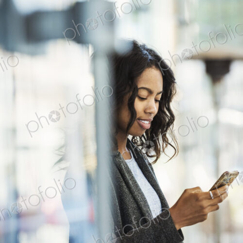 A woman on a city street, checking her mobile phone. A woman on a city street, checking her mobile phone.