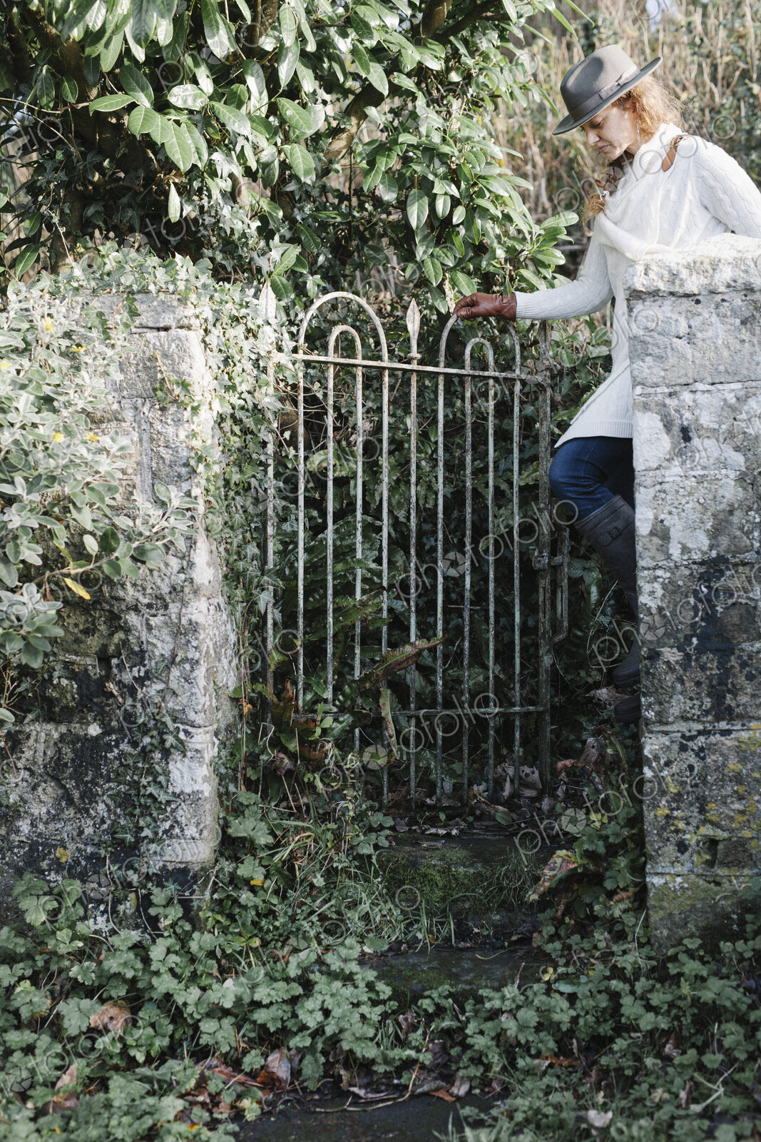 A woman opening a garden gate.