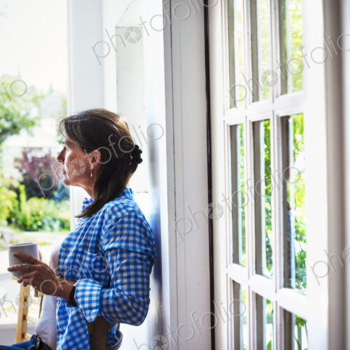 A woman outdoors holding a cup of coffee. A woman outdoors holding a cup of coffee.
