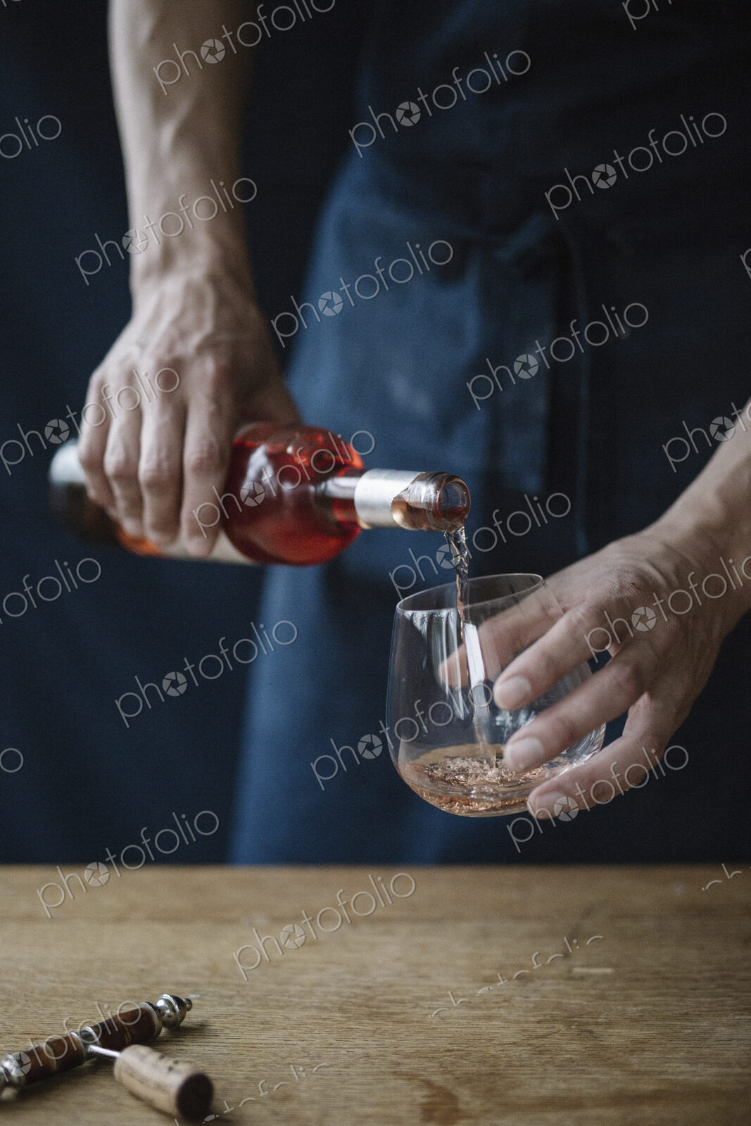 A woman pouring a drink from a bottle.