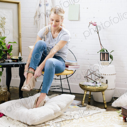 A woman putting on suede boots. A woman putting on suede boots.