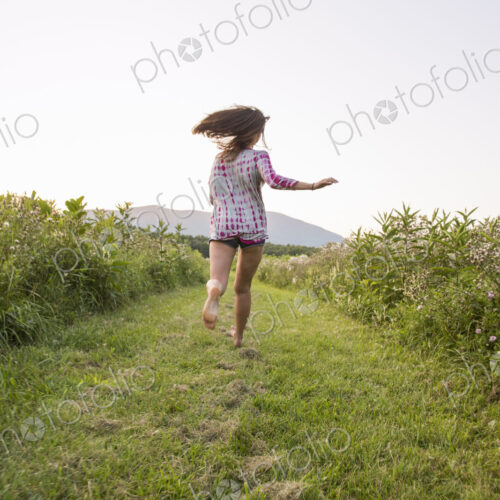 A woman running along a path in a meadow. A woman running along a path in a meadow.