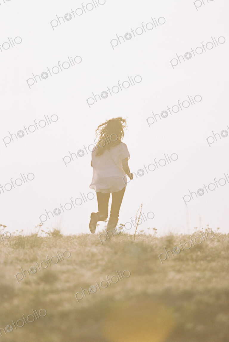 A woman running with her long hair fanning out behind her.