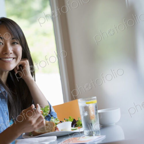 A woman seated eating in a cafe.