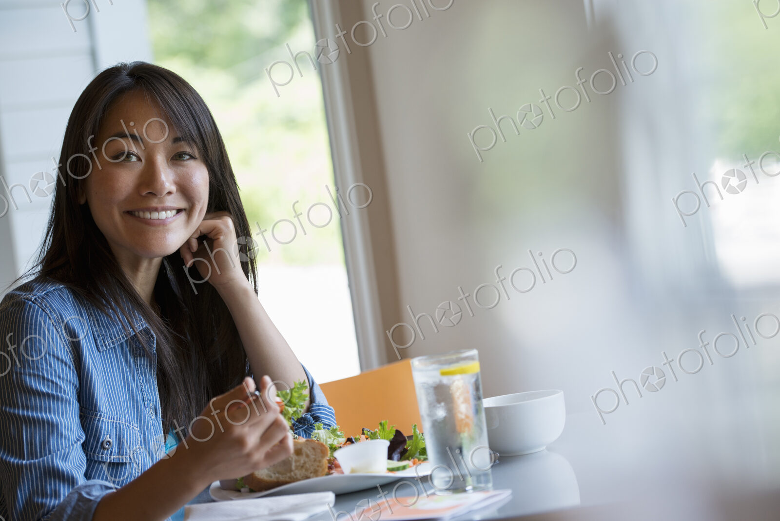 A woman seated eating in a cafe.