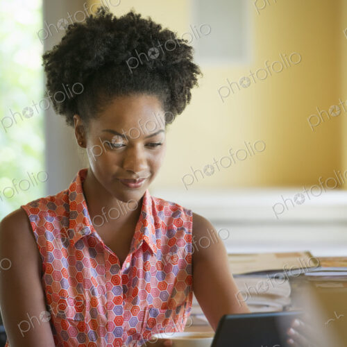 A woman seated having a cup of coffee. Holding an ebook or a digital tablet. A woman seated having a cup of coffee. Holding an ebook or a digital tablet.