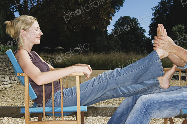 A woman seated receiving a foot massage.