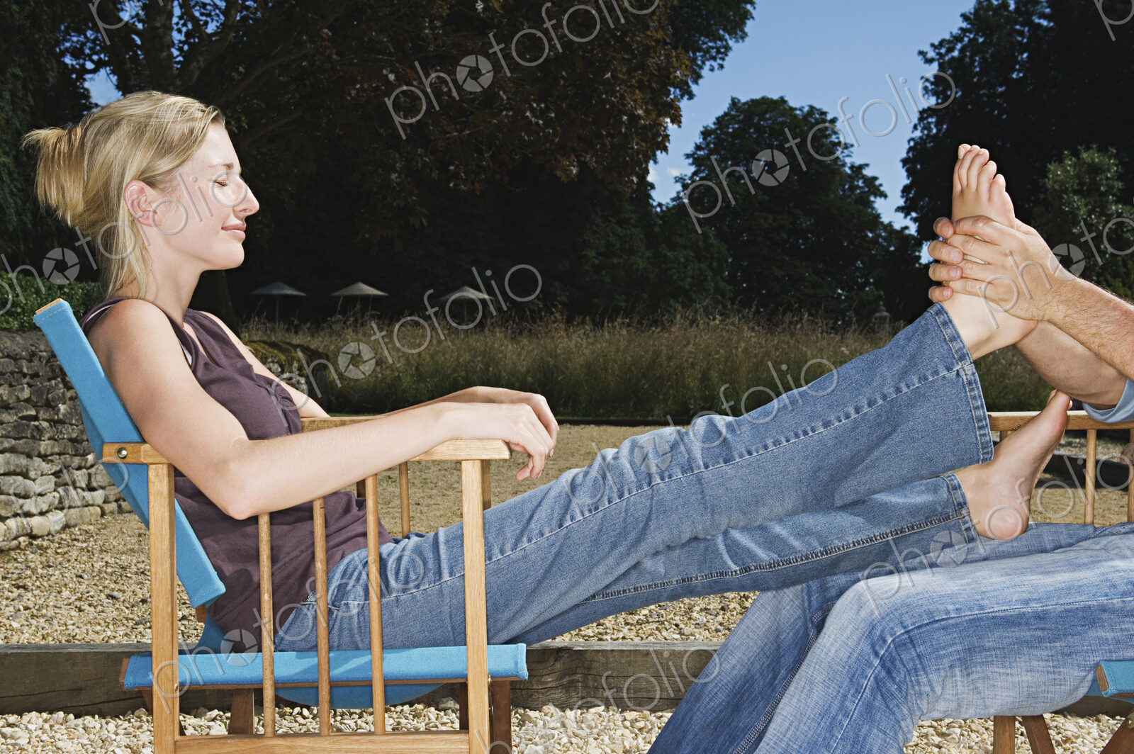 A woman seated receiving a foot massage.
