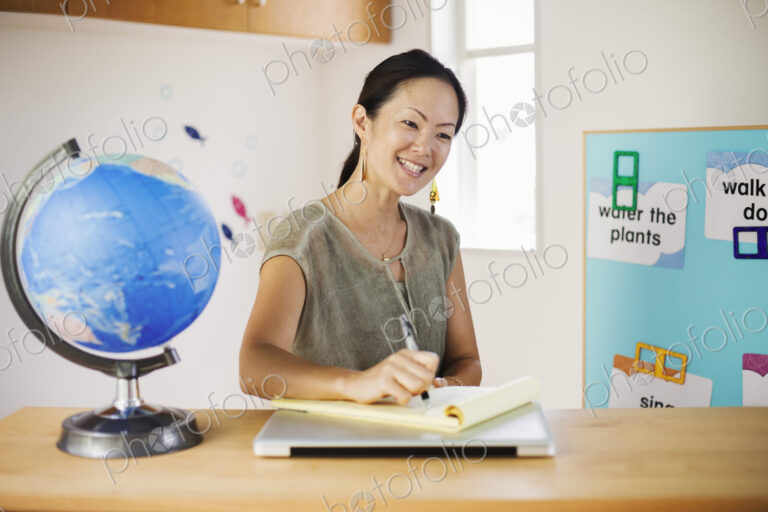 A woman sitting at a desk in a classroom.
