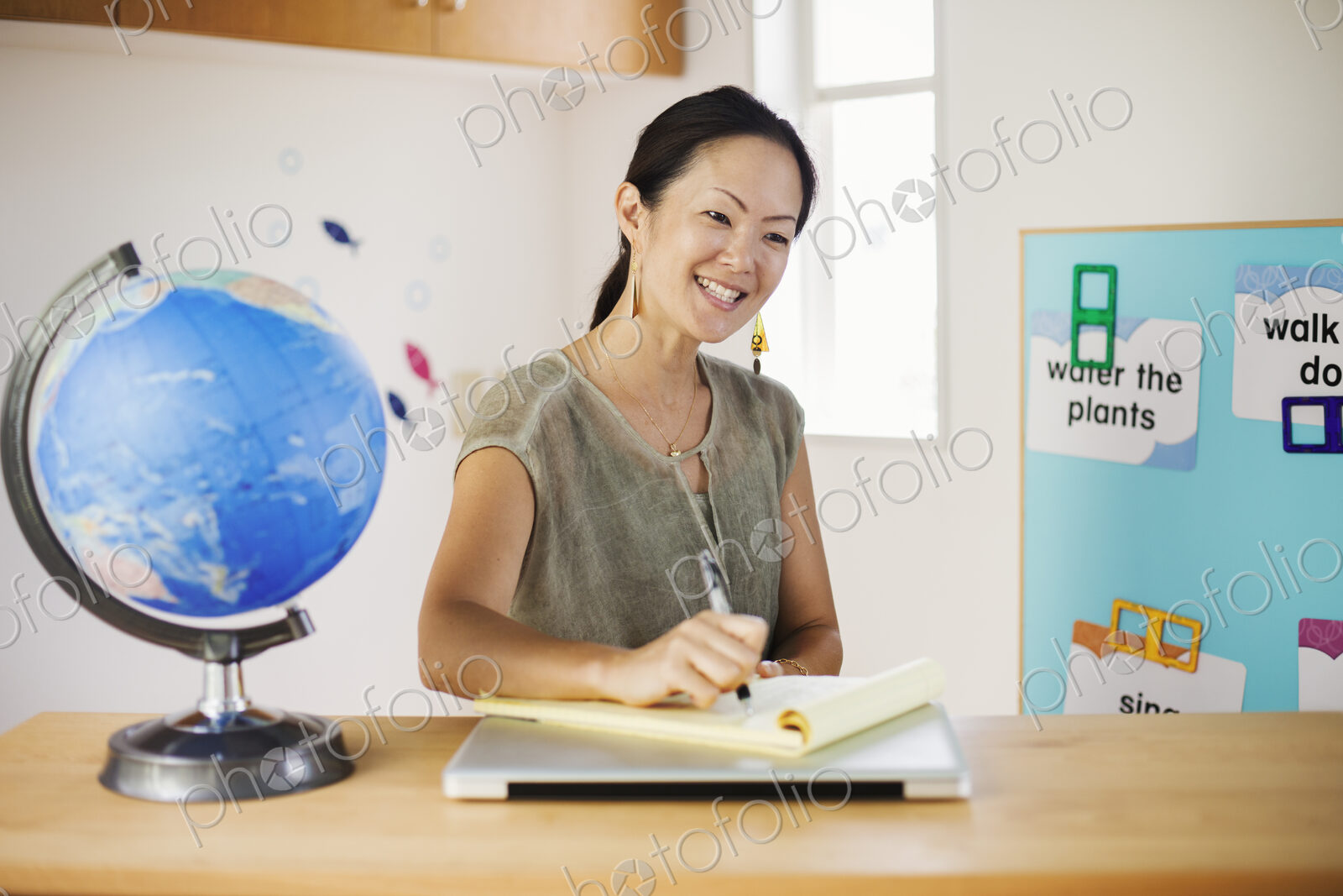 A woman sitting at a desk in a classroom.