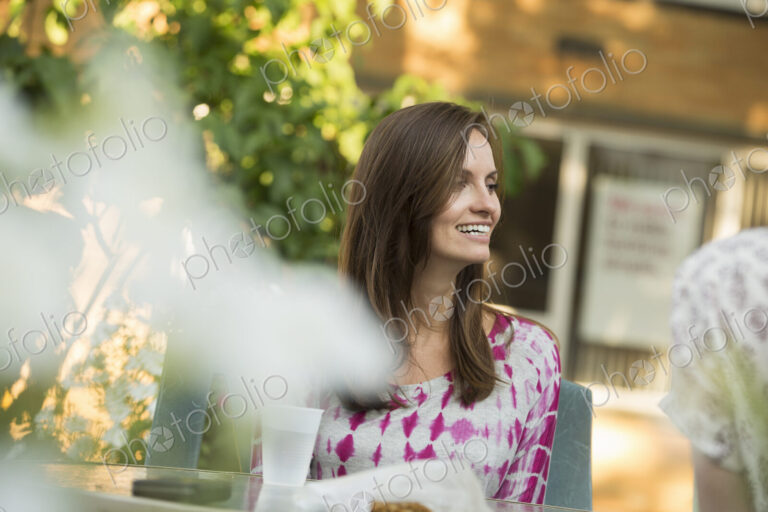 A woman sitting at a table in a garden.