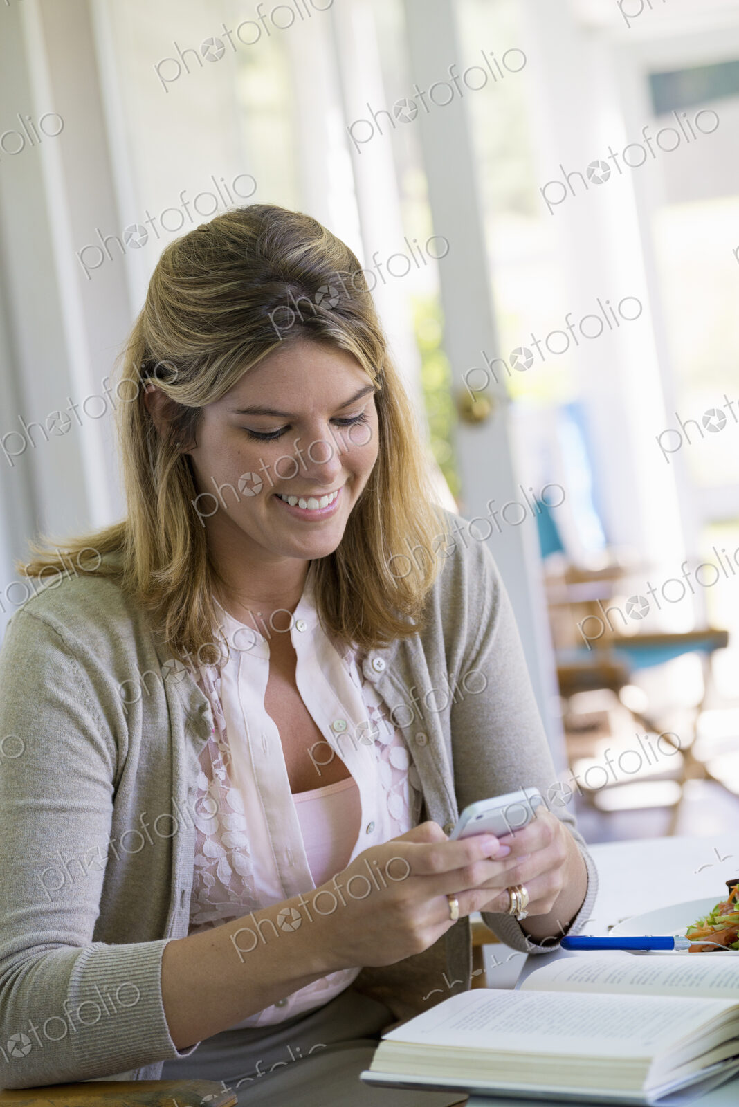 A woman sitting at a table using a smart phone.