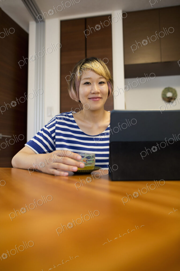 A woman sitting at a table with a laptop computer.
