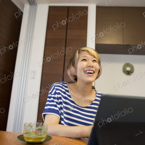 A woman sitting at a table with a laptop computer. A woman sitting at a table with a laptop computer.