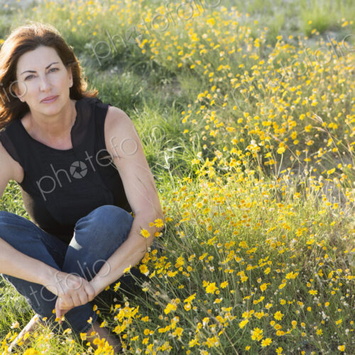 A woman sitting cross legged on the ground. A woman sitting cross legged on the ground.