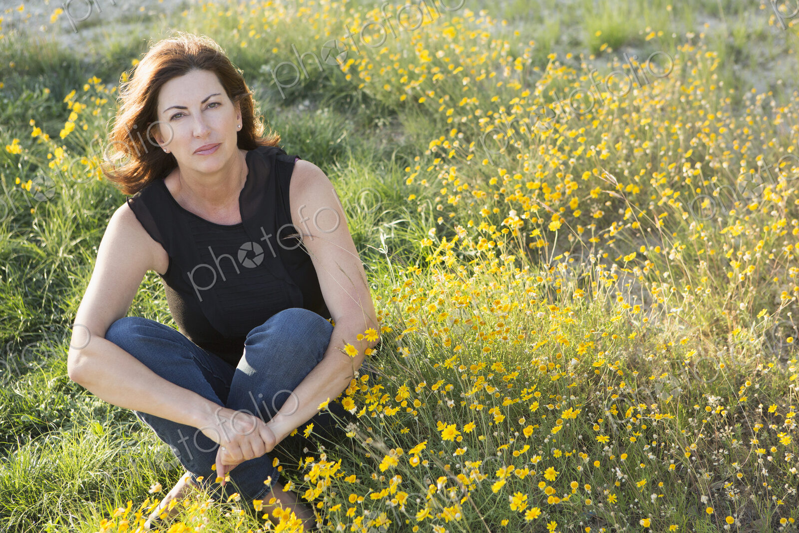 A woman sitting cross legged on the ground.