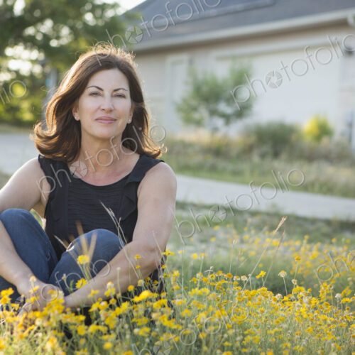 A woman sitting cross legged on the ground. A woman sitting cross legged on the ground.