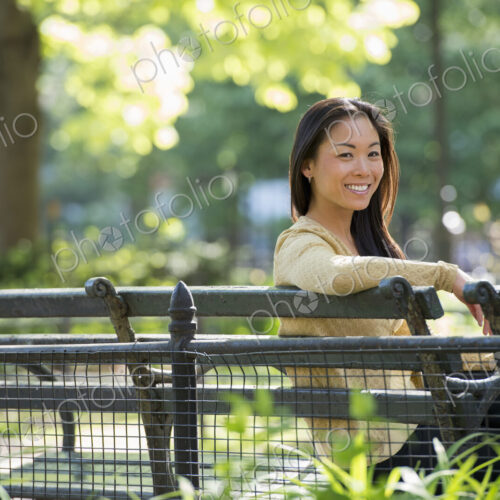 A woman sitting in a city park on a bench in the sunshine. A woman sitting in a city park on a bench in the sunshine.
